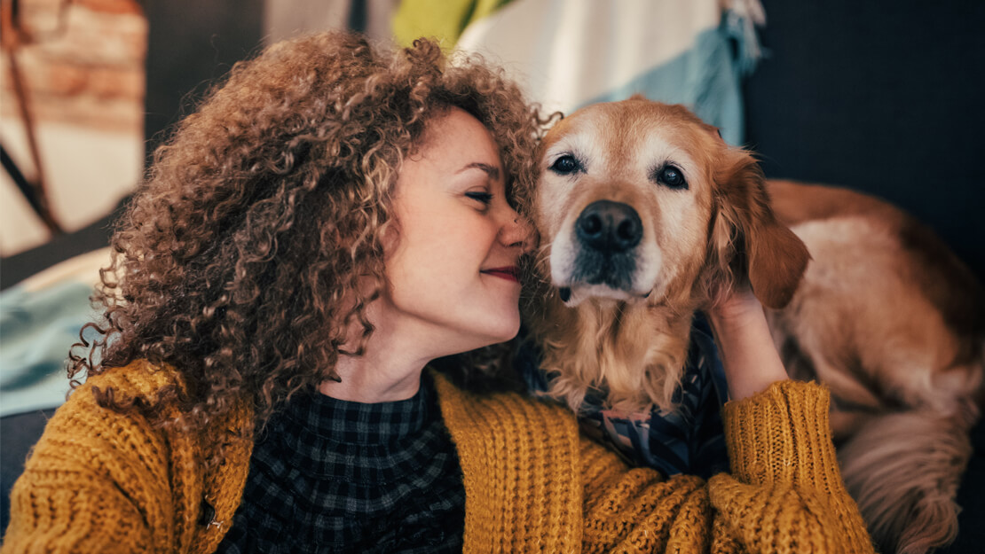 woman snuggling her golden retriever