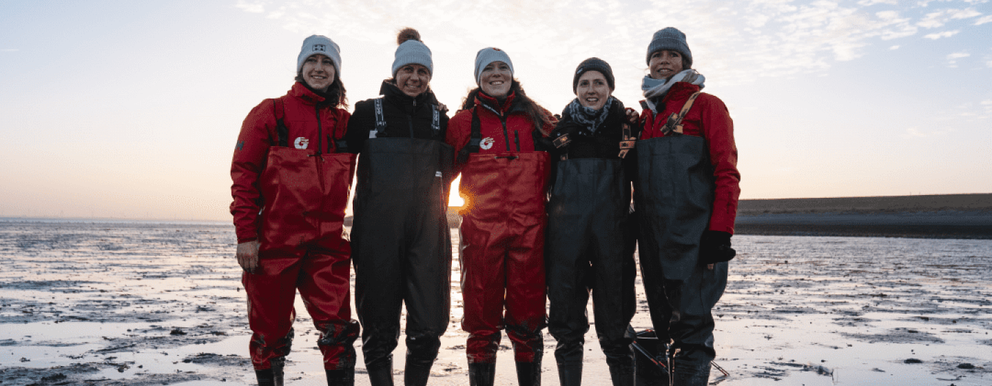 Five people working in a cold beach