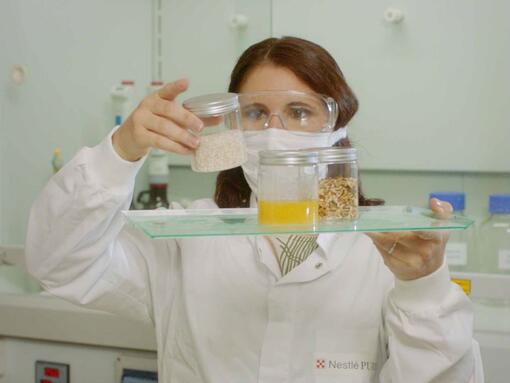 Female scientist looking at ingredients in pots